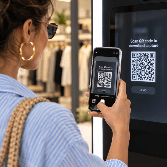 A shopper scanning a StyleFrame QR code from an in-store display with her phone